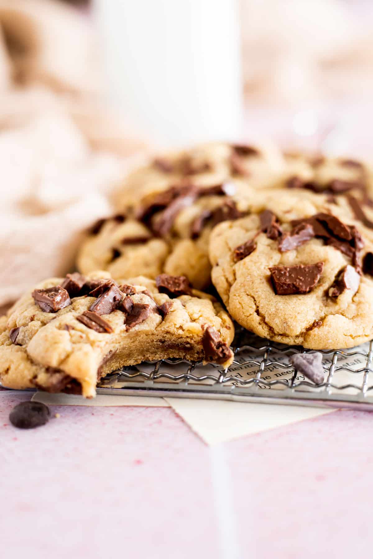 1 cookie with a bite in it on a cooling rack of chocolate chip cookies.