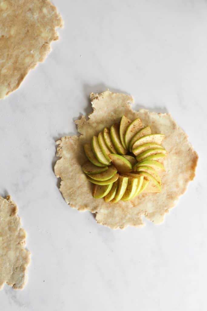 apple arranged in a circle in rolled out pie crust