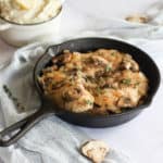 dairy free chicken marsala in a cast iron skillet with a blue linen