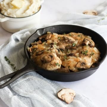 chicken with mushrooms and gravy in cast iron pan