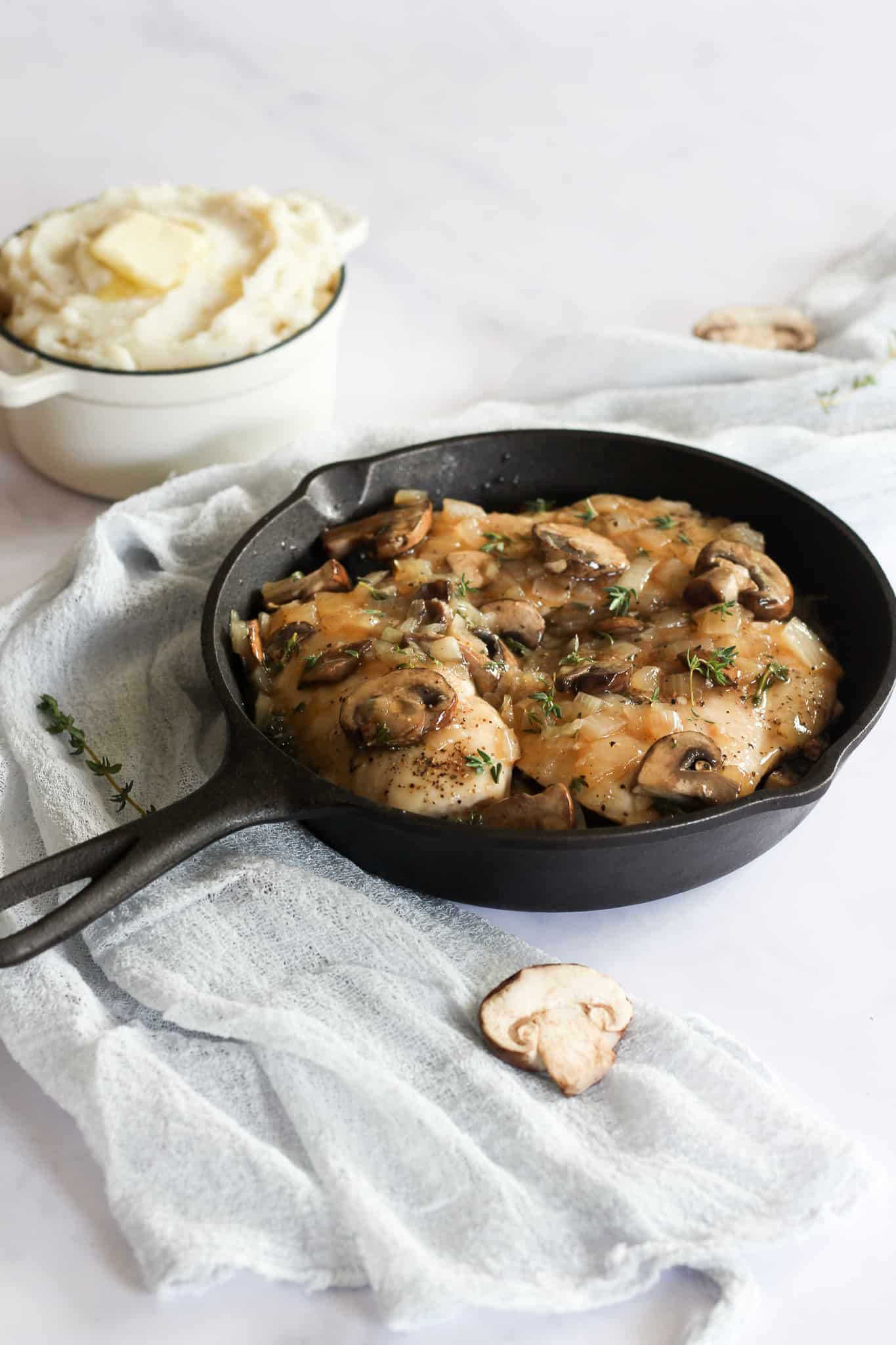 chicken with mushrooms and gravy in cast iron pan