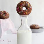 chocolate sprinkle donut on top of a milk jug