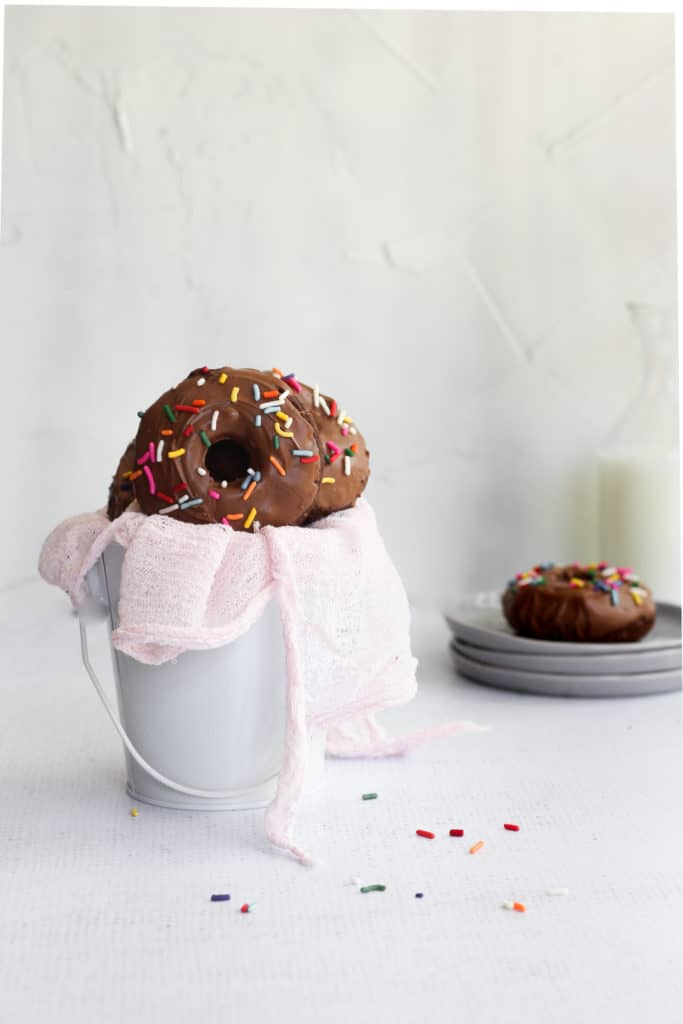 baked double chocolate cake donut in a white bucket with a pink linen
