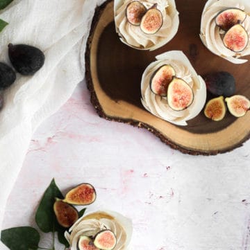 vanilla cupcakes topped with figs on a wood board