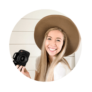 girl in brown hat smiling and holding a camera