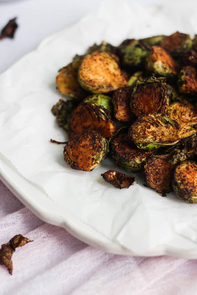 white plate of quick air-fryer brussels sprouts on a pink napkin