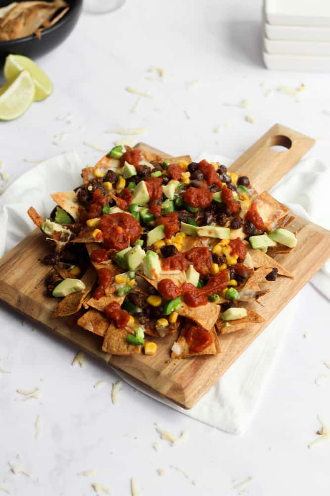 healthy nachos on a wood board on a white napkin