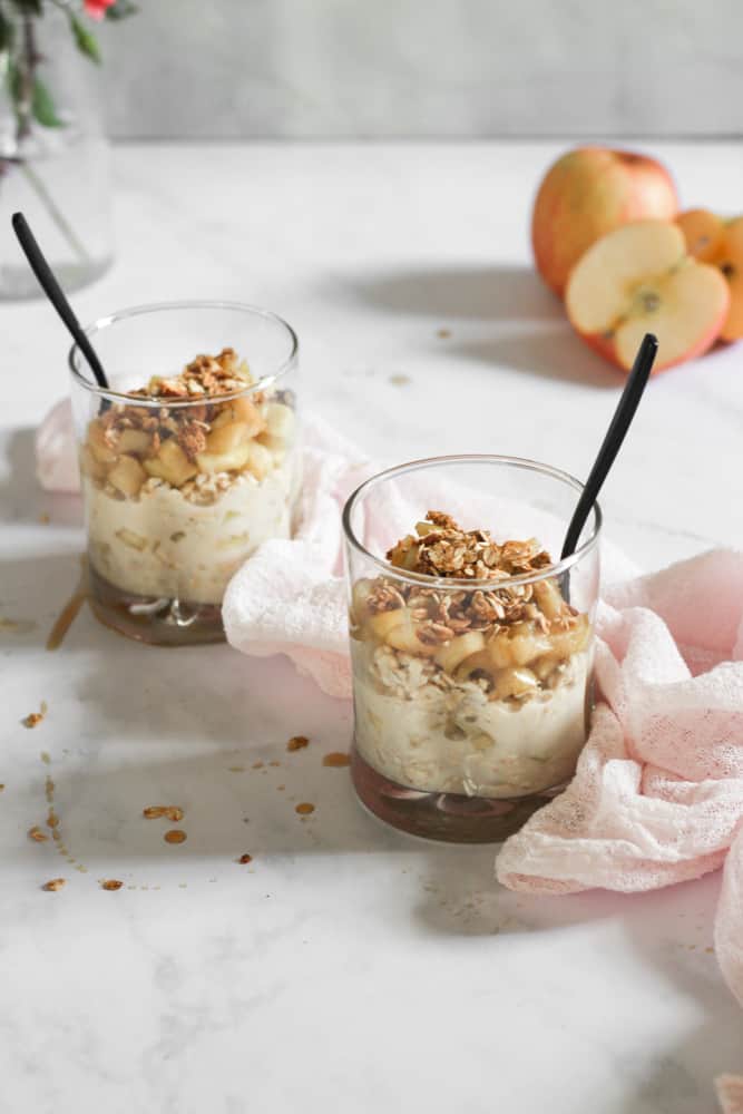 vegan apple pie overnight oats in two cups on a white backdrop