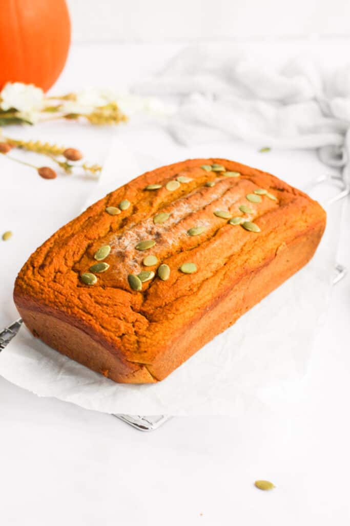 loaf of healthy pumpkin bread topped with pumpkin seeds.
