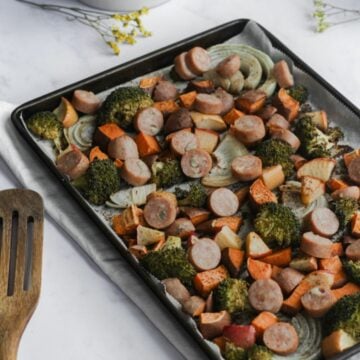 chicken sausage, broccoli, sweet potatoes, and onions on a sheet pan.