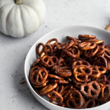 pumpkin spice coated pretzels in a white bowl.