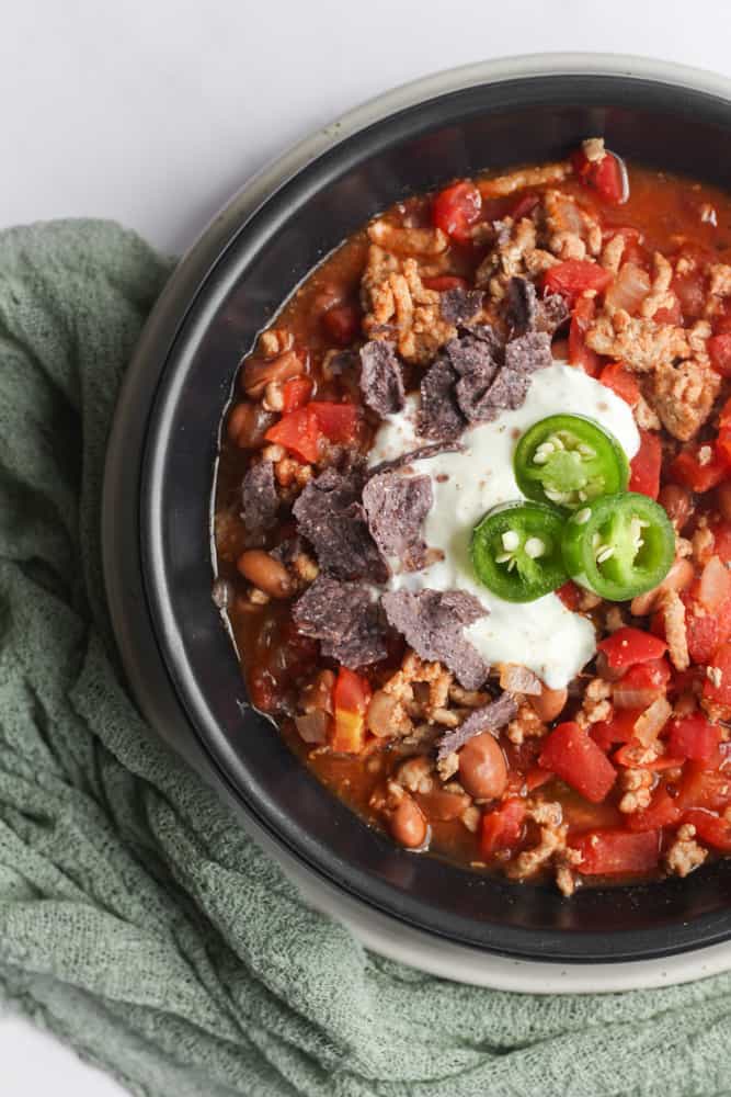 black bowl of 5 ingredient chili with a green napkin