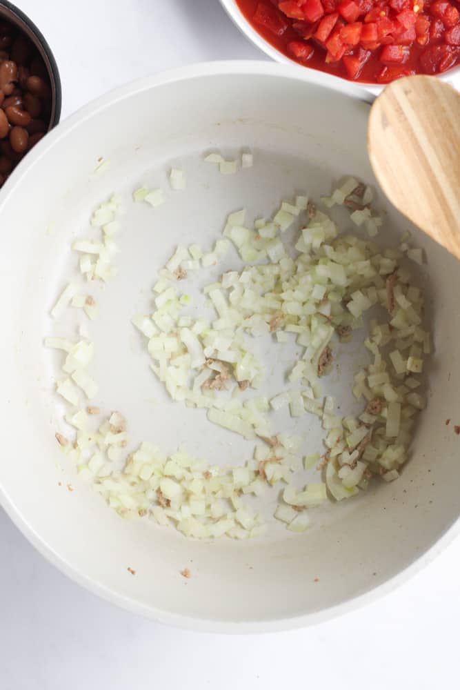 diced onion sauteeing in a white pot