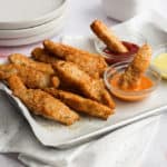 gluten free chicken tenders on a baking sheet with dipping sauces