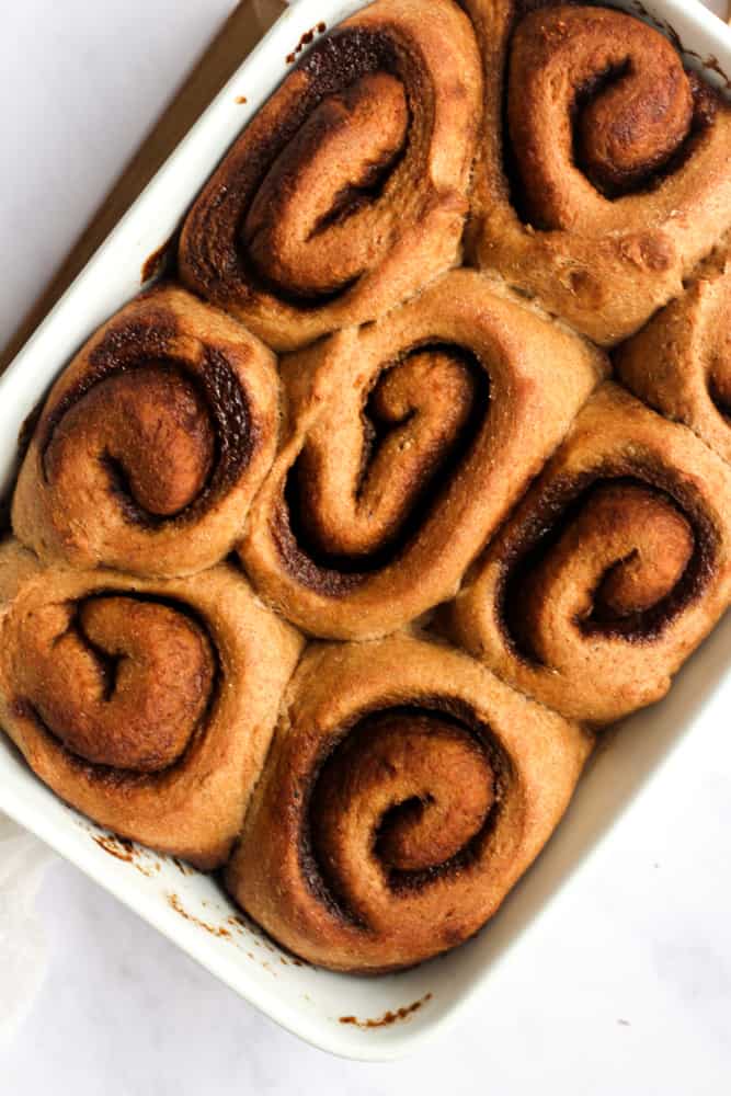healthy whole wheat cinnamon rolls on a white baking