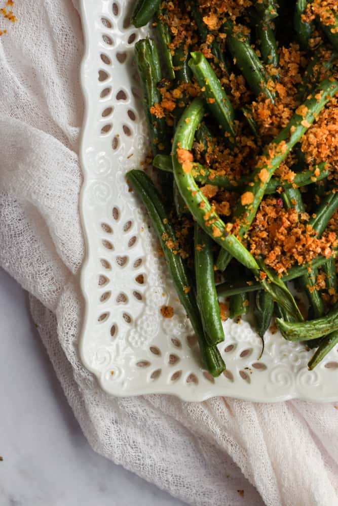 corner of platter full of healthy air fryer green beans with a light pink napkin