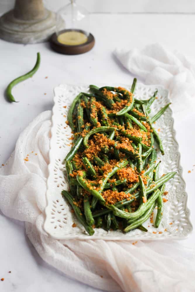 white platter layered on a pink napkin full of spicy air fried green beans
