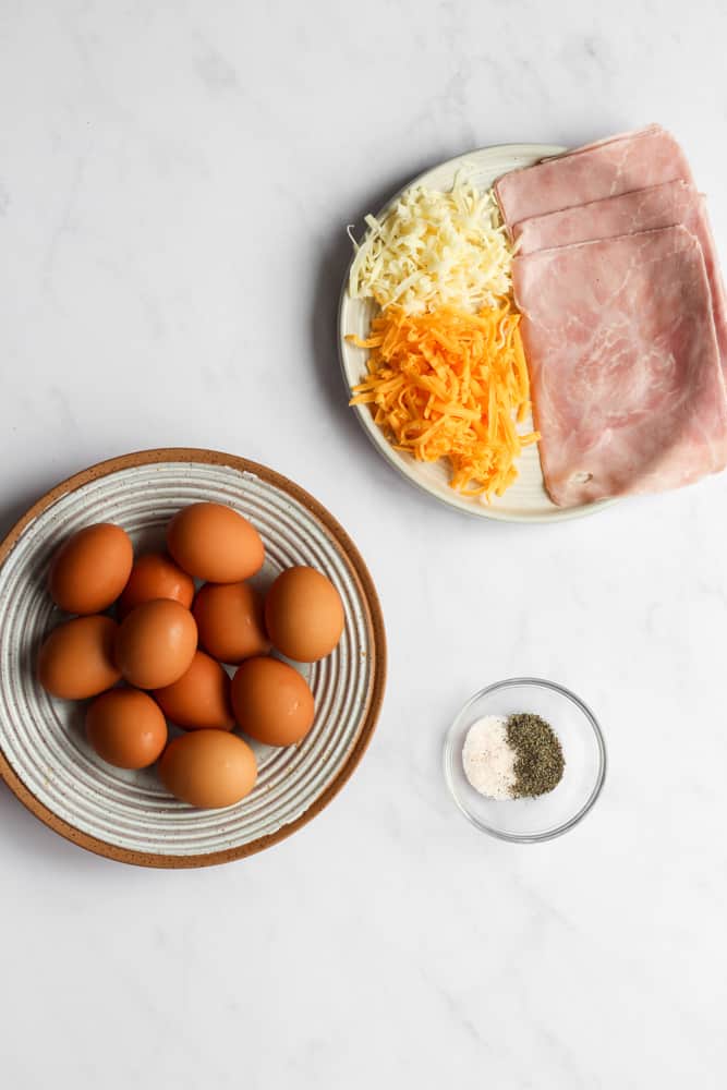 ham and egg cup ingredients on a white backdrop