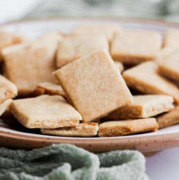 honey shortbread cookies in a gray bowl with a green linen