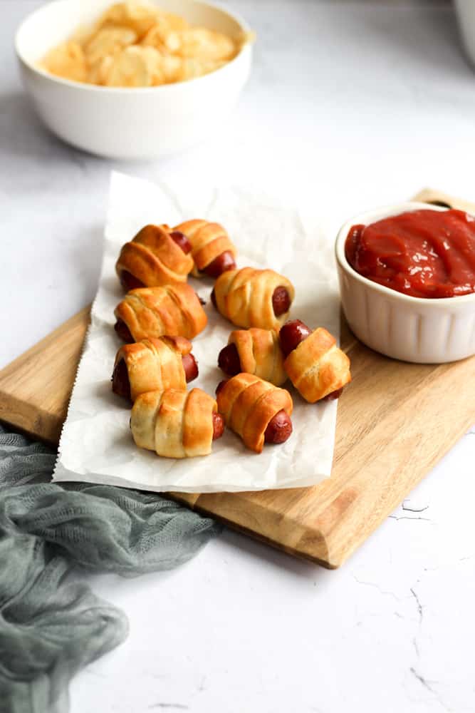 easy 2 ingredient appetizer on a wood board with parchment paper and a bowl of ketchup