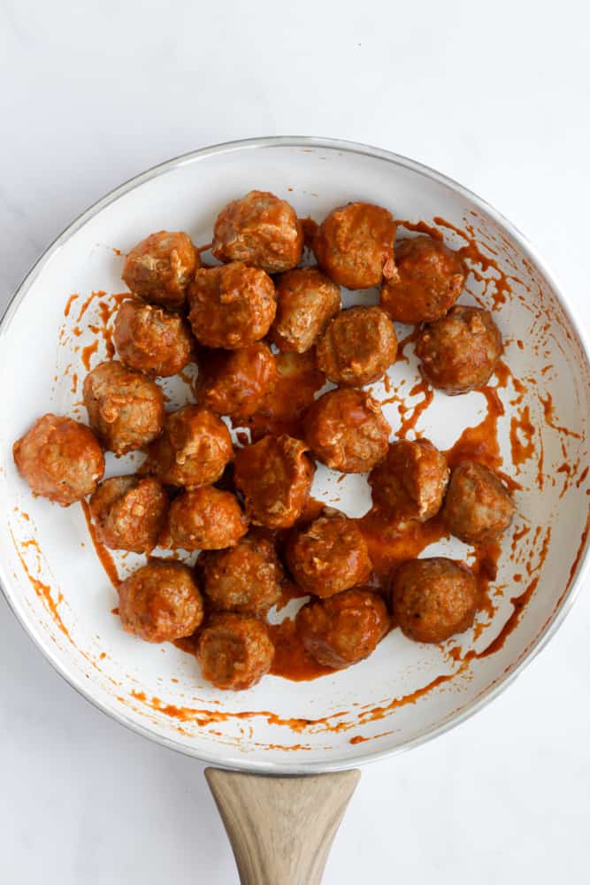 air fryer turkey meatballs in a white pan with BBQ sauce.