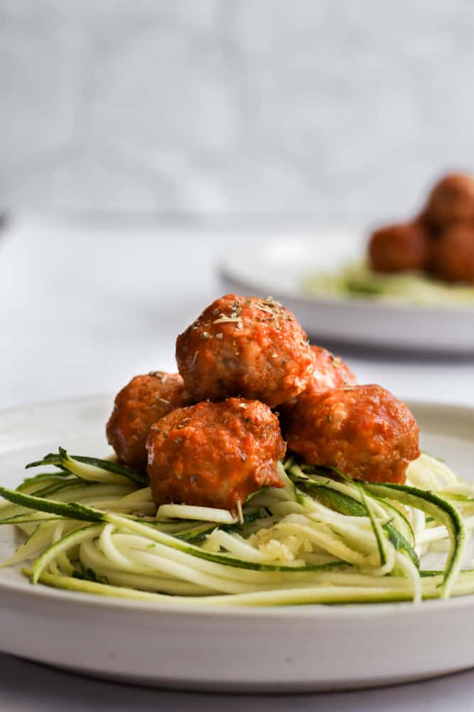 healthy turkey meatballs on zucchini noodles on a white plate
