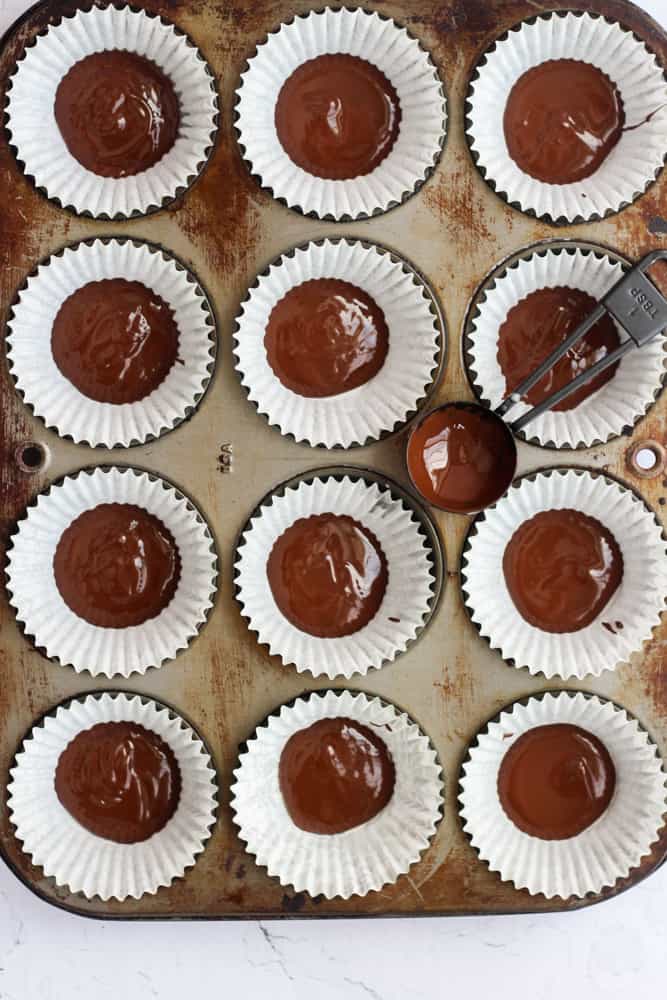 melted chocolate in the bottom cupcake liners, lining a muffin tin pan