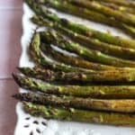 balsamic asparagus with charred tips on a white platter