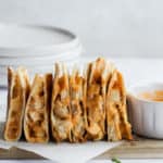 healthy buffalo chicken quesadilla standing on end on parchment paper
