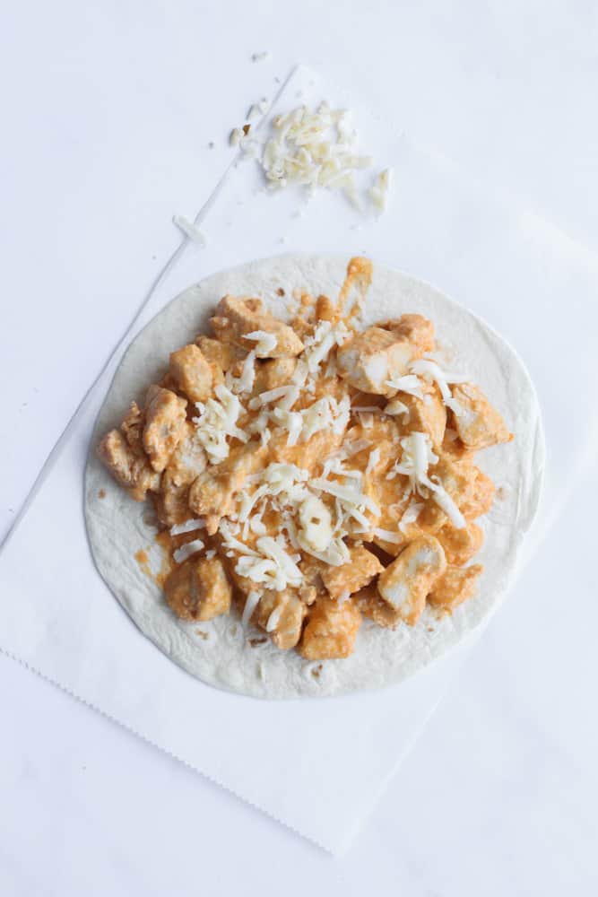 buffalo chicken quesadilla open faced on a piece of parchment paper