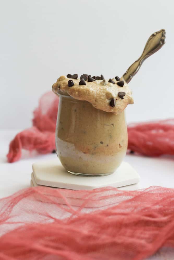 gluten free edible cookie dough in a clear jar with a silver spoon