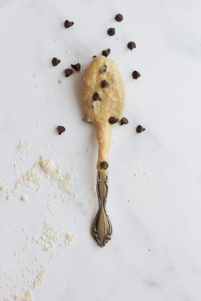 a spoonful of edible vegan cookie dough on a white backdrop with mini chocolate chips