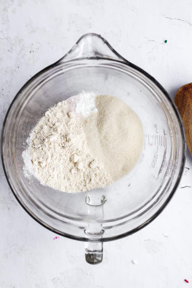 dry ingredients for healthy gluten free cake in a glass bowl on a white backdrop
