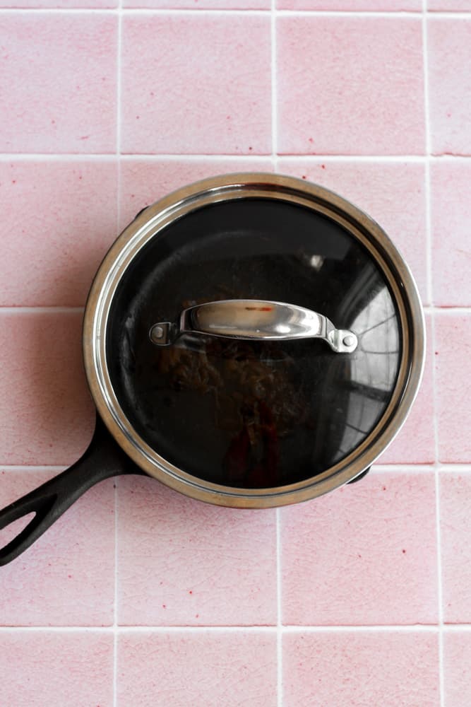 cast iron pan with a lid on a pick backdrop