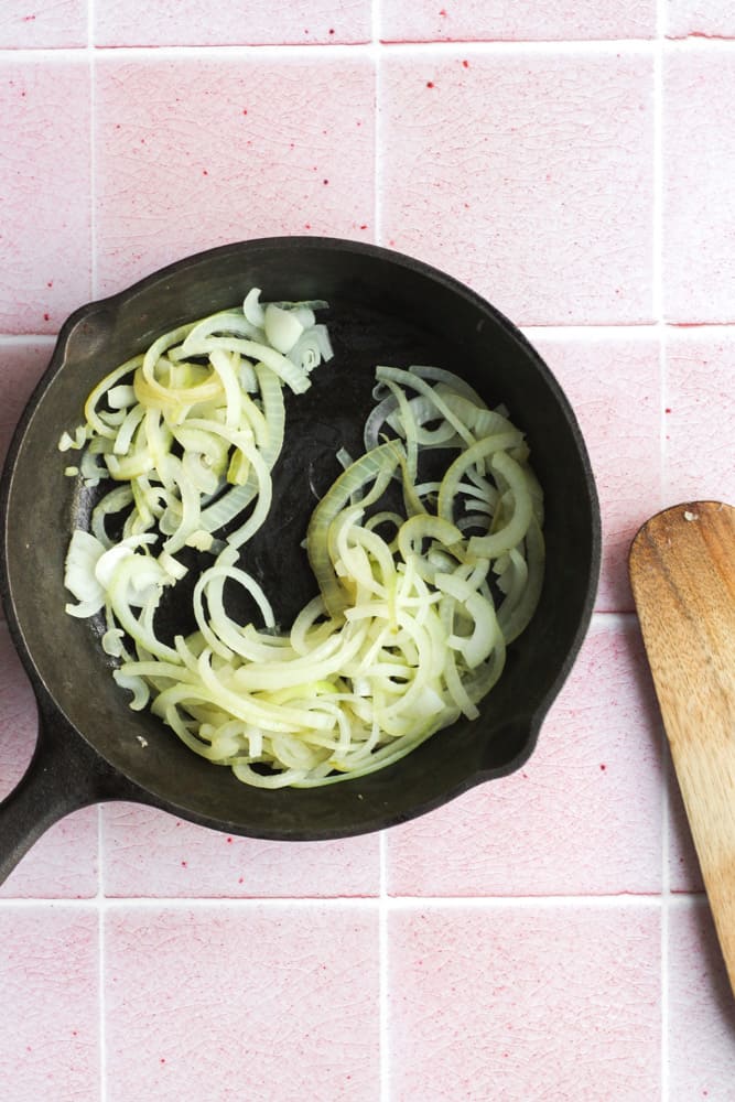 onions cooking in a cast iron pan without oil