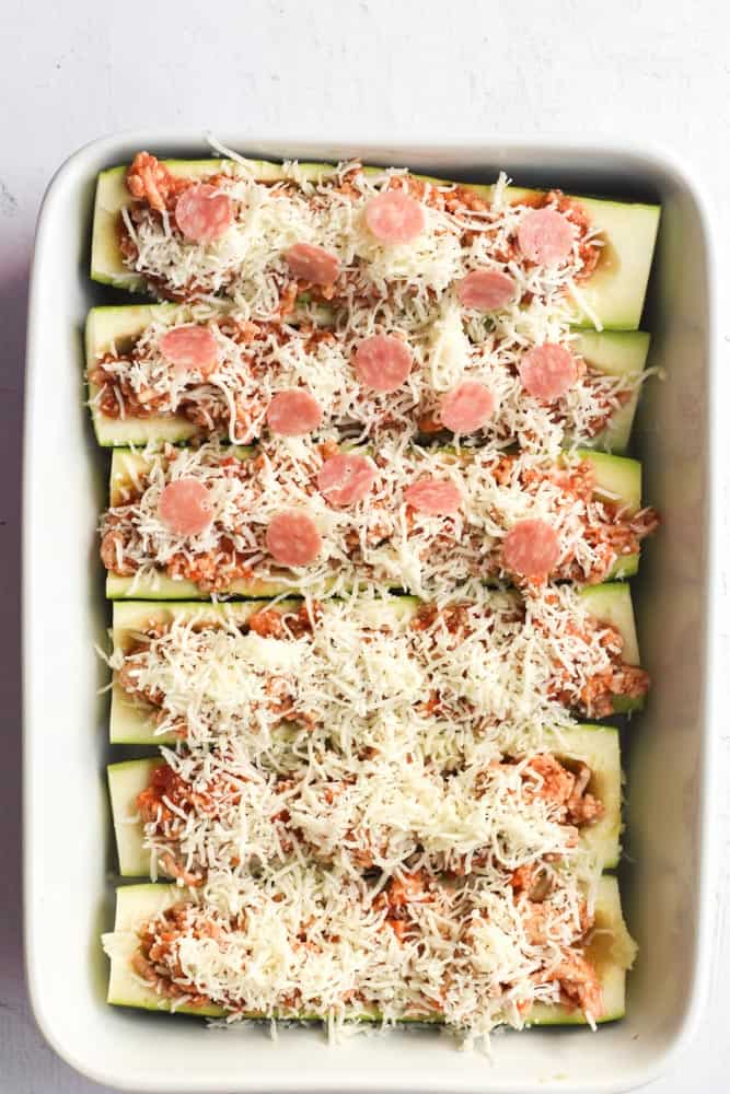 healthy zucchini pizzas topped with shredded cheese and mini pepperoni