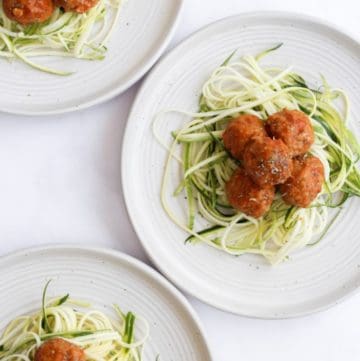 air fryer turkey meatballs served over zucchini noodles on 3 white plates