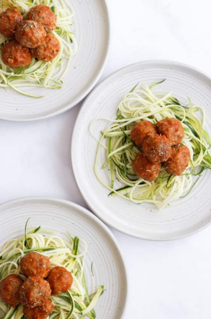 air fryer turkey meatballs served over zucchini noodles on 3 white plates