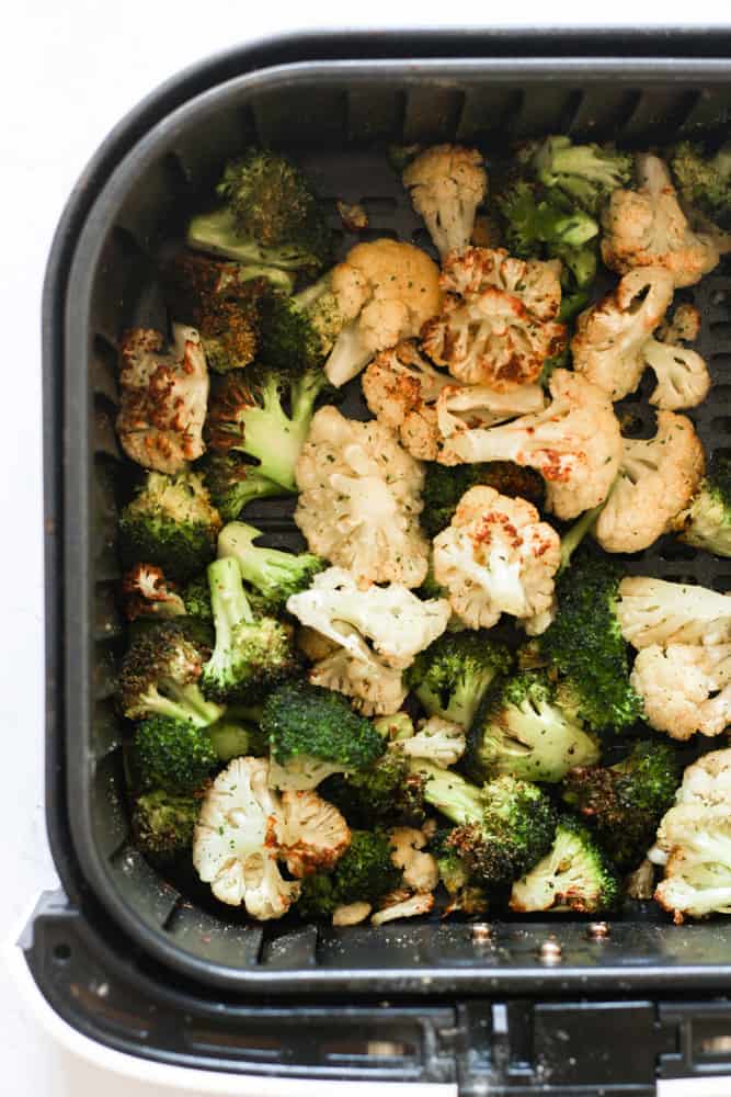broccoli and cauliflower cooked in the basket of an air fryer