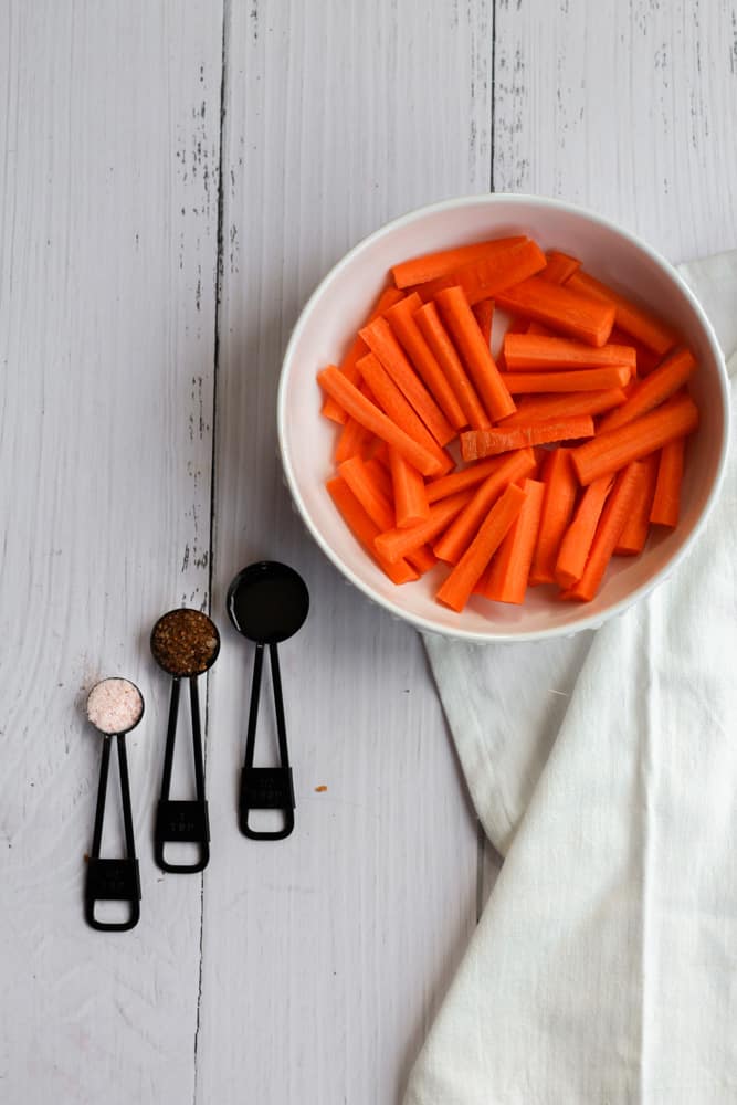 ingredients for carrot fries in the air fryer on a white backdrop