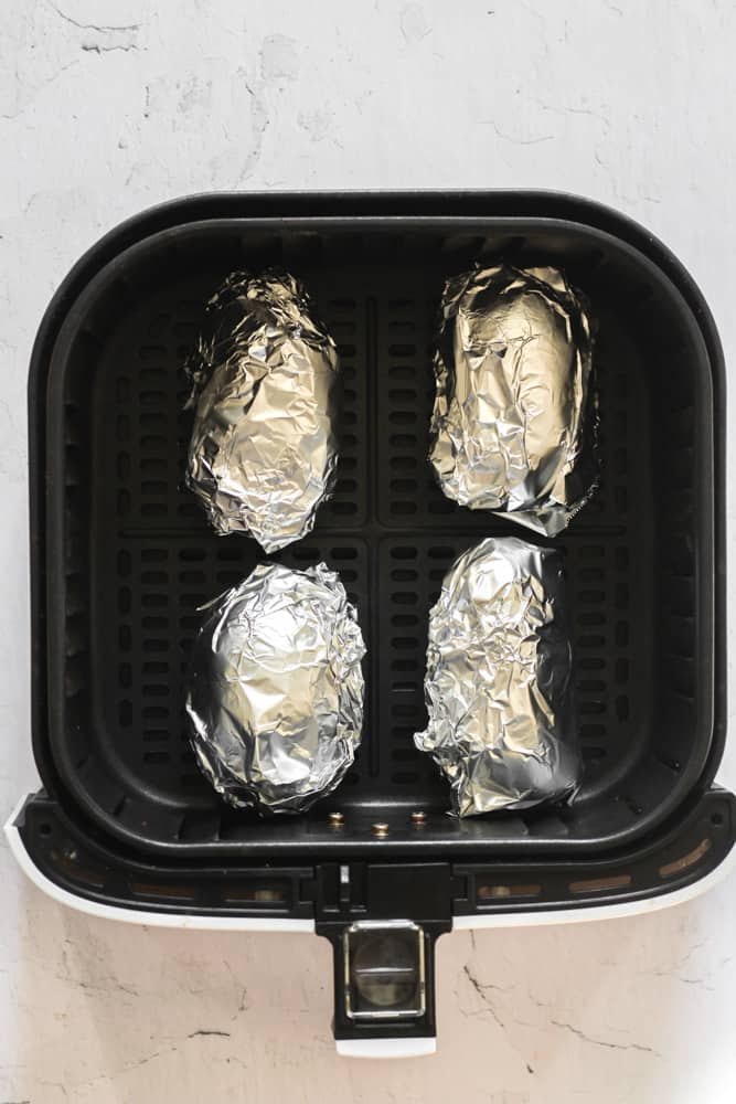 baked potatoes wrapped in aluminum foil in the air fryer