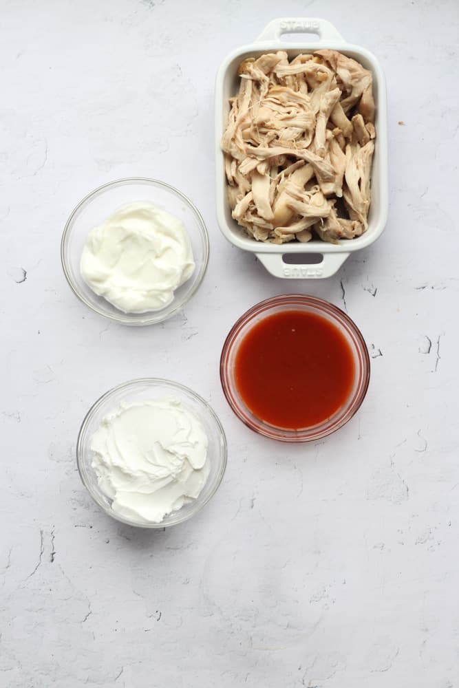 healthy buffalo chicken dip ingredients on a white backdrop