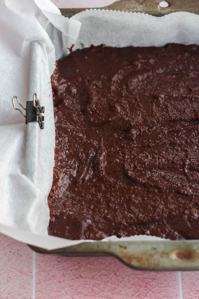 healthy gluten free chocolate cake in a baking pan lined with parchment paper