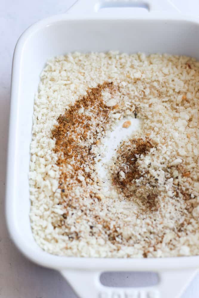 gluten free Panko mixed with seasonings to form a breading in a white baking dish