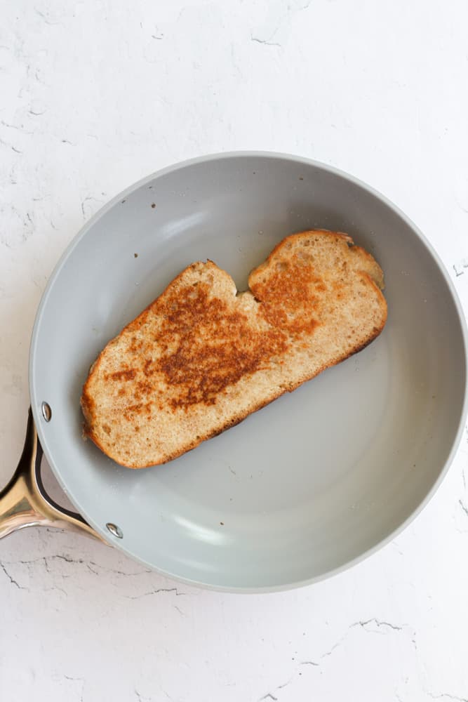 sourdough French toast with a golden brown crust cooked in a blue pan