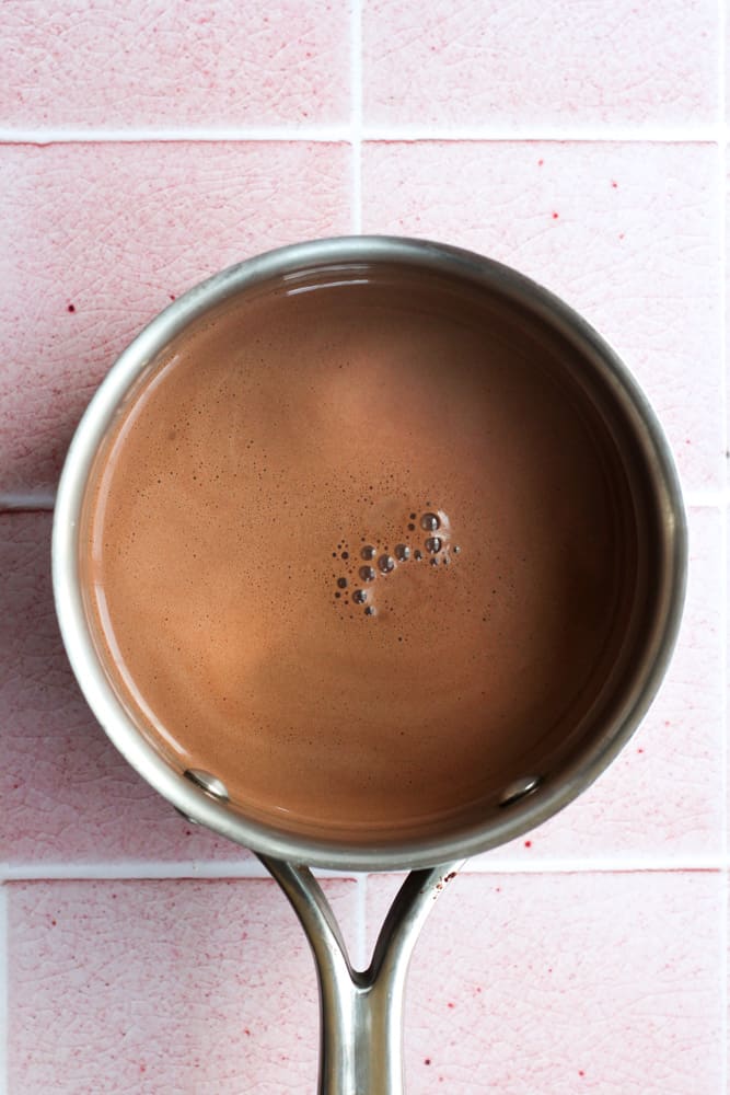 healthy hot chocolate in a silver pot on a pink backdrop