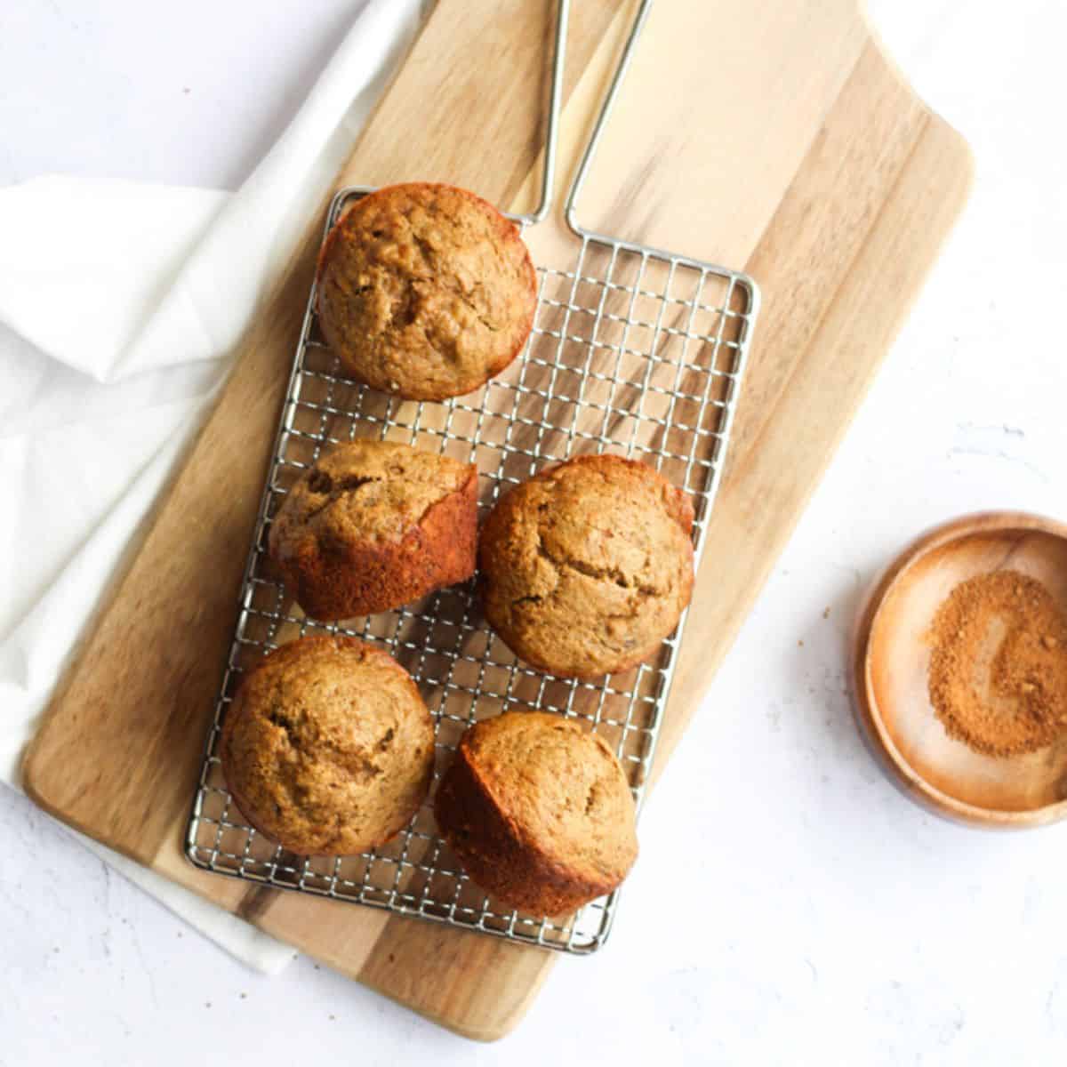 5 ingredient banana bread muffins on a wooden cutting board.