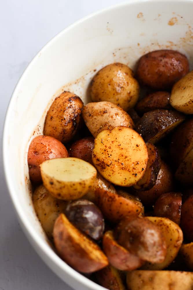 Seasoned baby potatoes in a white bowl