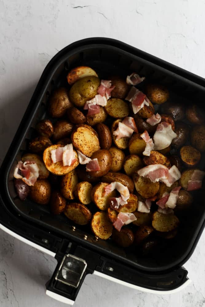 Baby potatoes in a single layer in a black air fryer basket