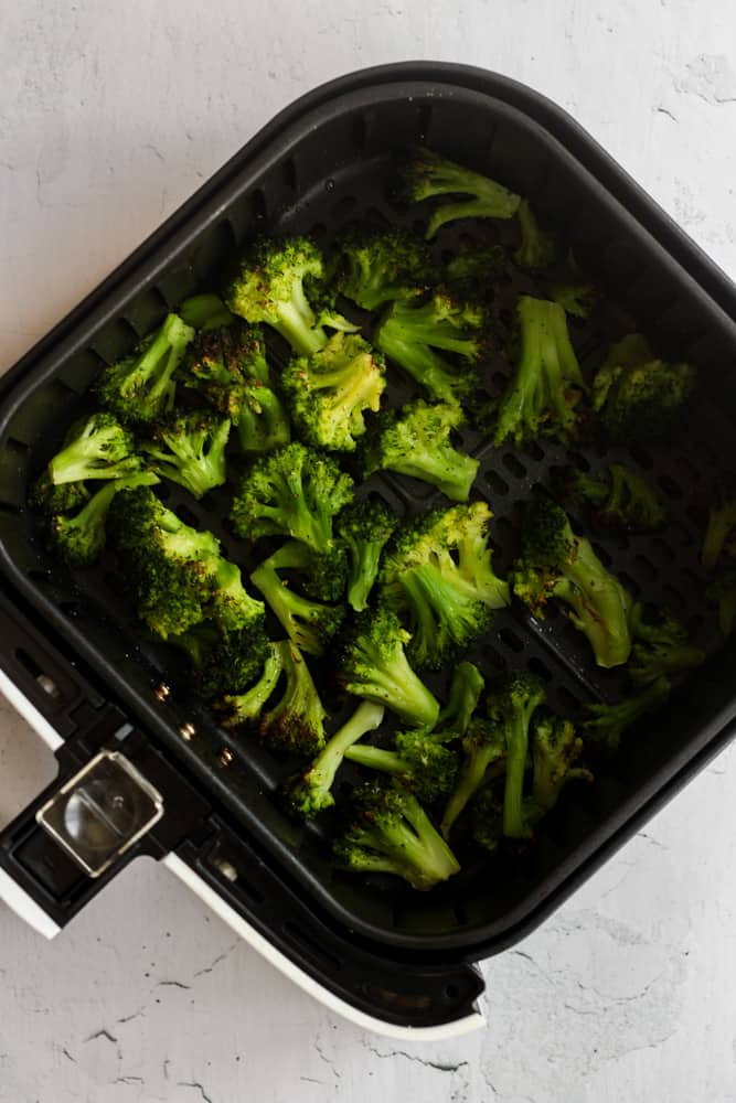 crispy broccoli in air fryer basket.